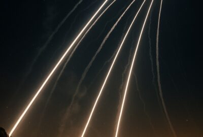 Iron Dome interceptor missile trails streak across dark night sky over Israeli city