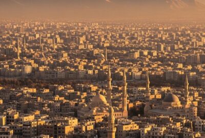 Vast Tehran cityscape stretching toward snow-capped Alborz Mountains at sunrise
