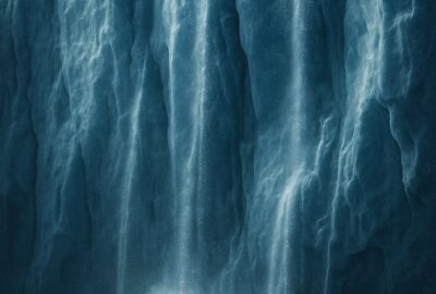 Massive Antarctic ice wall with waterfalls cascading into dark churning ocean below