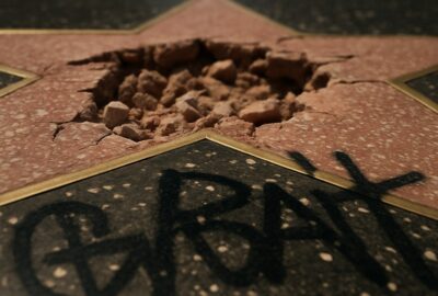 Smashed and graffiti-covered Trump Hollywood Walk of Fame star on Boulevard sidewalk