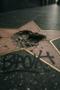 Smashed and graffiti-covered Donald Trump Hollywood Walk of Fame star on Boulevard sidewalk