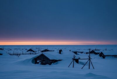 Deep blue twilight glowing over snow-covered Arctic town during polar night in Alaska