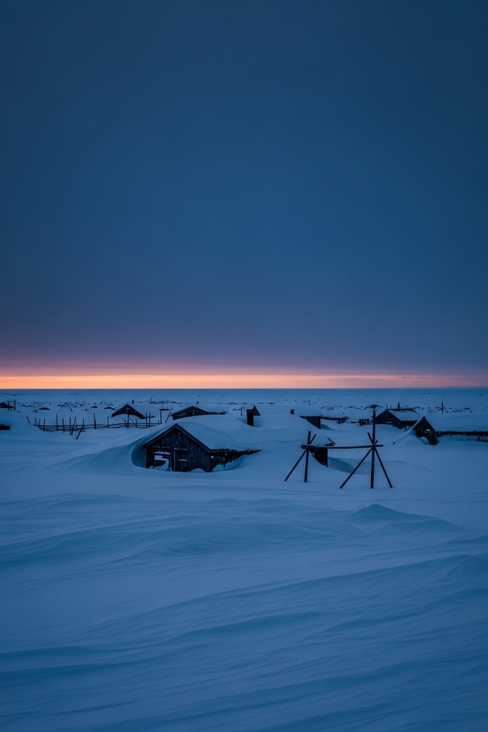 Deep blue twilight glowing over snow-covered Arctic town during polar night in Alaska