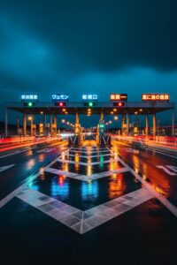 Long exposure night shot of Tokyo expressway toll gates glowing in dense urban traffic