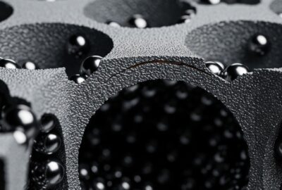 Close-up cross-section of lightweight metal foam composite armor material showing hollow spheres