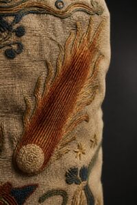 Close-up of the Halley's Comet Bayeux Tapestry scene — an embroidered hairy star on aged linen