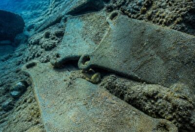 Bronze Age oxhide tin and copper ingots recovered from the Uluburun shipwreck, resting on the seabed
