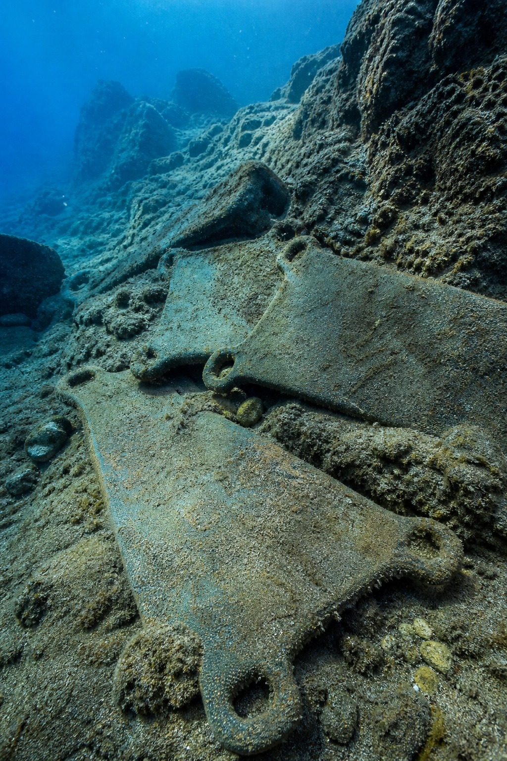 Bronze Age oxhide tin and copper ingots recovered from the Uluburun shipwreck, resting on the seabed